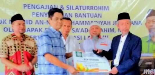 Ketua PWM Jatim Saad Ibrahim menyerahkan infak Rp 105 juta untuk pembangunan Masjid An Nur Muhammadiyah Jembrana. (Zainul/PWMU.CO)