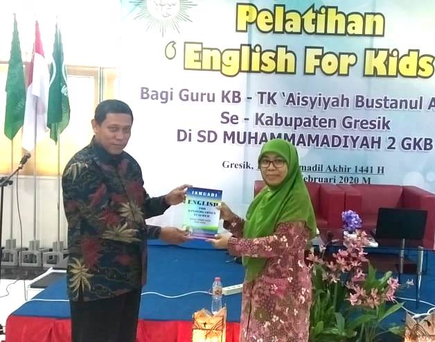 Estu Rahayu menerima buku English for Kid dari Mr Ismuadi. Dalam forum ini Estu menjelaskan empat tugas guru TK. (Heppy/PWMU.CO)
