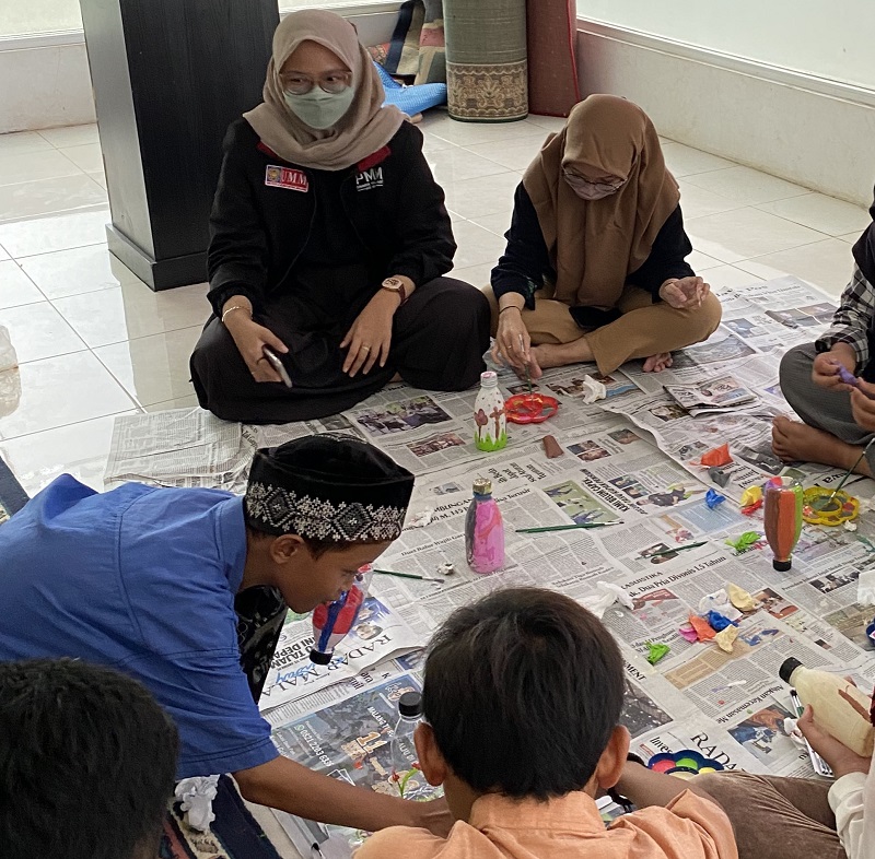 Mahasiswa UMM mengajari anak Panti Asuhan Yasibu Malang membuat kerajinan celengan dari botol bekas, Selasa (28/12/21).