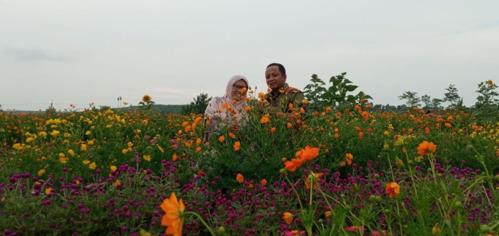 Kembangkan potensi desa, Dosen UMM Pradana Boy bersama istrinya menikmati keindahan taman bunga yang dirintisnya (Nely Izzatul/PWMU.CO)