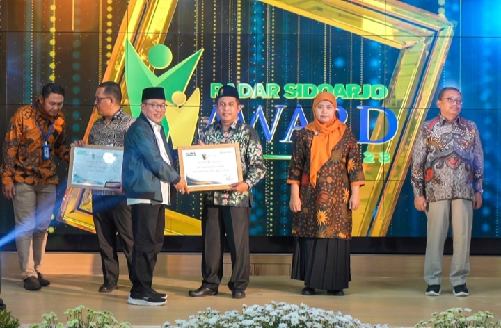 Kepala Smamda Sidoarjo, M Zainul Arifin SKom MM menerima penghargaan dari Radar Sidoarjo yang diserahkan oleh Ketua DPRD Sidoarjo, Rabu (15/3/2023) (Siti Agustini/PWMU.CO)