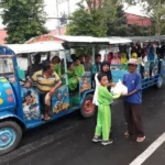 Pawai Naik Kereta Kelinci sambil Bagikan Bingkisan