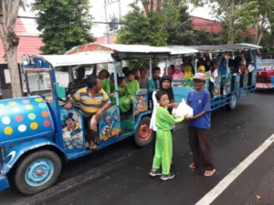 Pawai Naik Kereta Kelinci sambil Bagikan Bingkisan