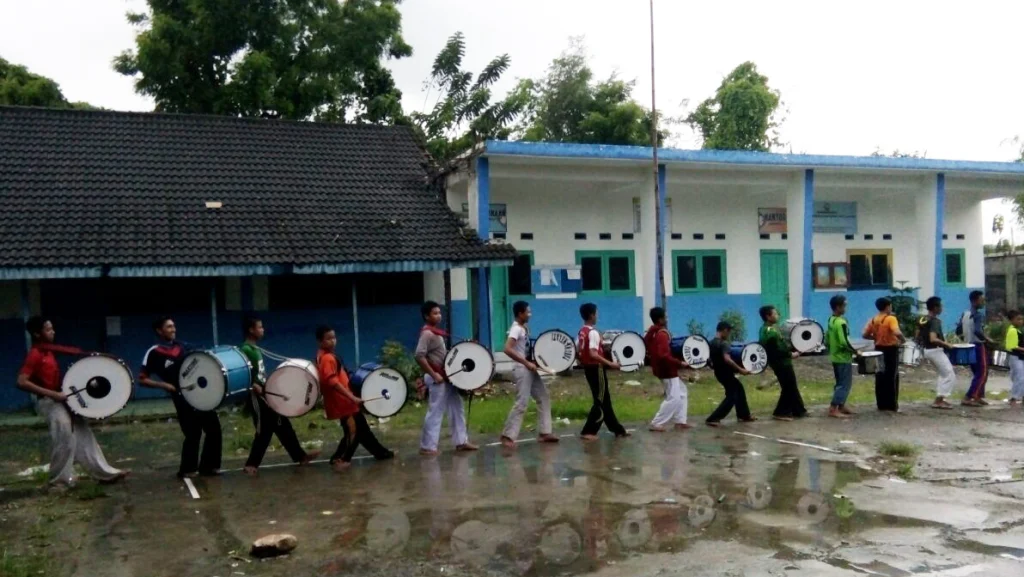 Dampingi Persiapan Santri, Ustadz Ini Rela Hujan-hujanan sambil Mainkan Alat Drum Band