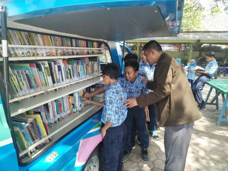Asyiknya Membaca Buku Perpustakaan Keliling di Bawah Pohon Beringin