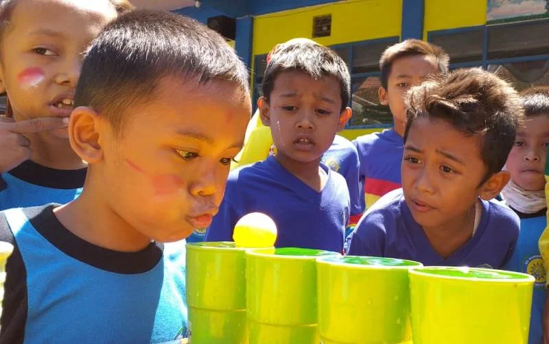 Penonton Gemes Lihat Anak-Anak Lomba Tiup Bola Pingpong